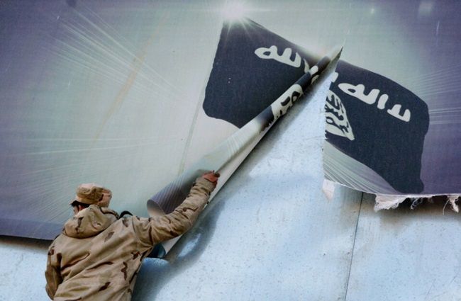 Tentara Irak menurunkan spanduk Islamic State (IS) atau ISIS. (AFP)